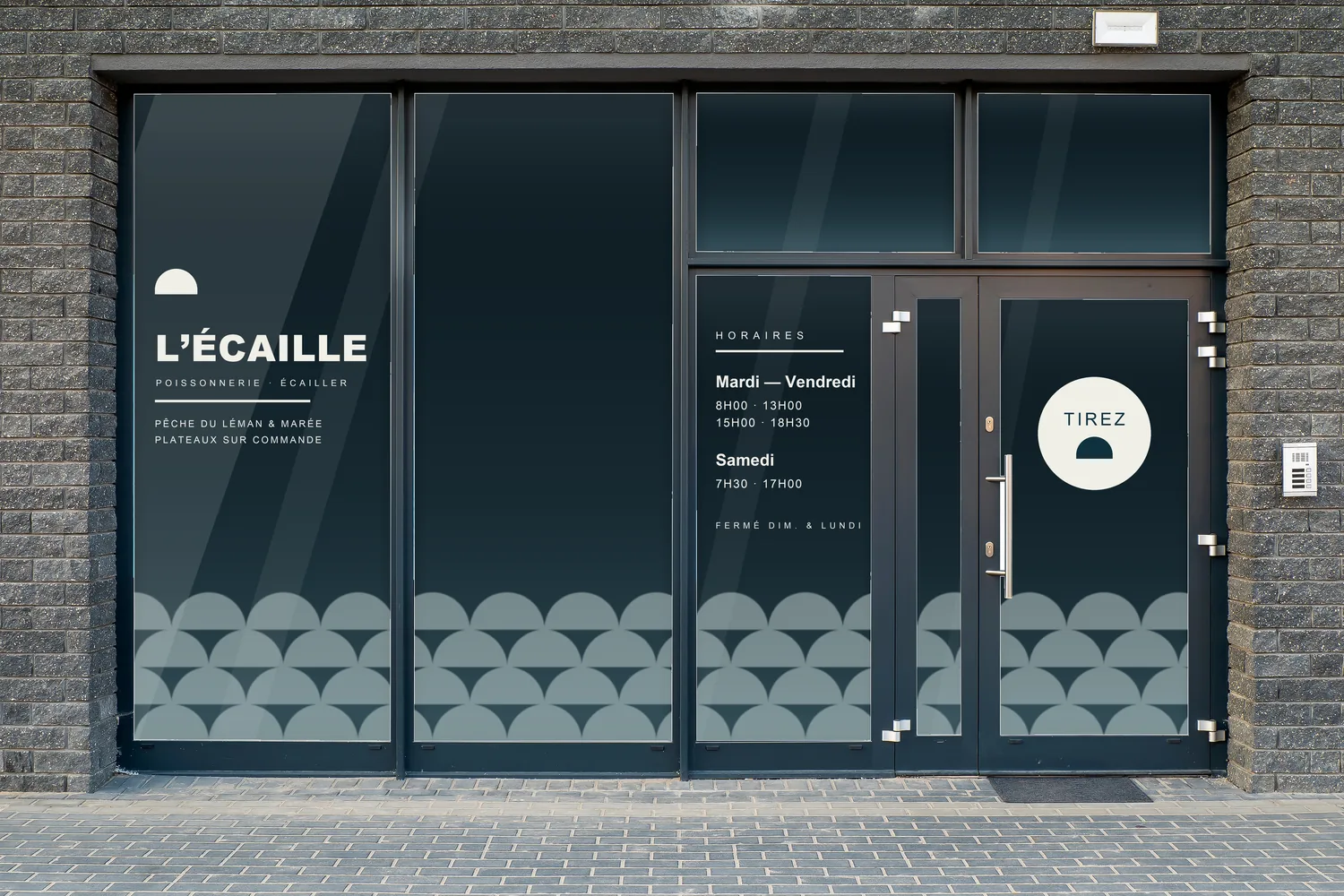 Vitrine de L’ÉCAILLE habillée en lettrage adhésif blanc craie, avec frise dépolie